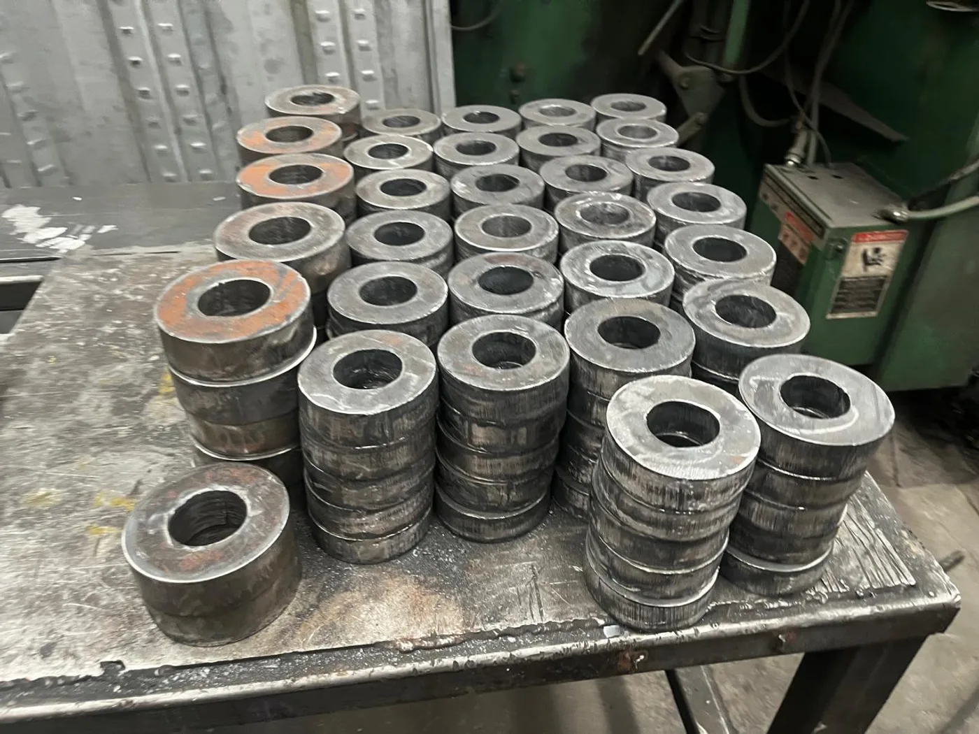 Arandelas de acero cortadas y apiladas por diámetro en el taller