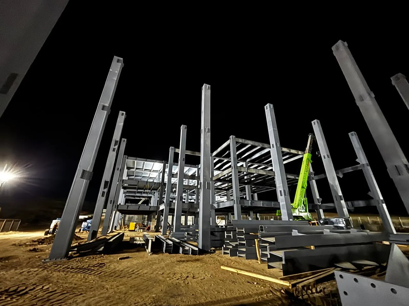 Montaje de estructura metálica trabajando de noche, bajo iluminación de obra