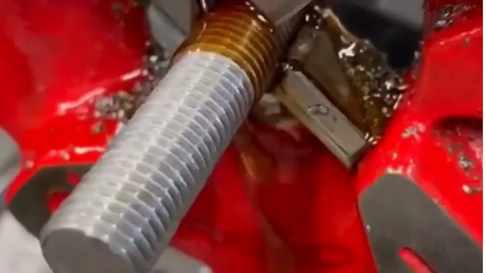 Dado de la roscadora cortando la cuerda en el extremo de una barra de acero