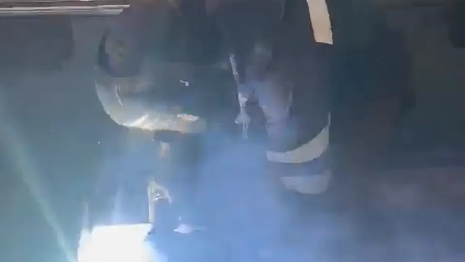 Soldador trabajando una pieza de acero, con el arco encendido y chispas